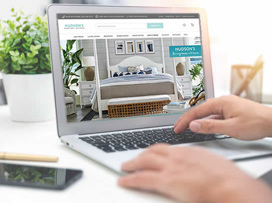 Person browsing Hudson's Furniture website on laptop